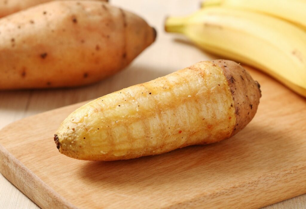 Grain-free banana sweet potato dog treat on a wooden board with sweet potatoes and banana in background