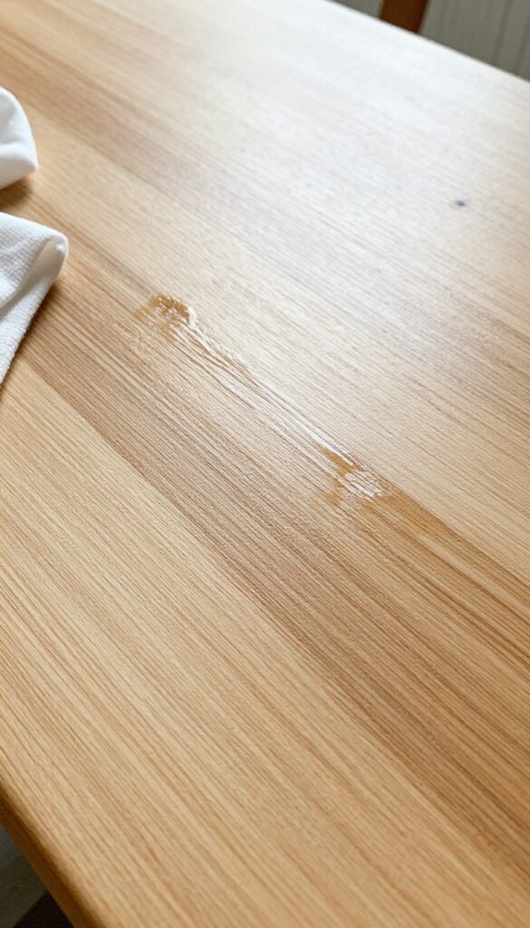Applying mineral oil to dry wood furniture to restore moisture and natural glow