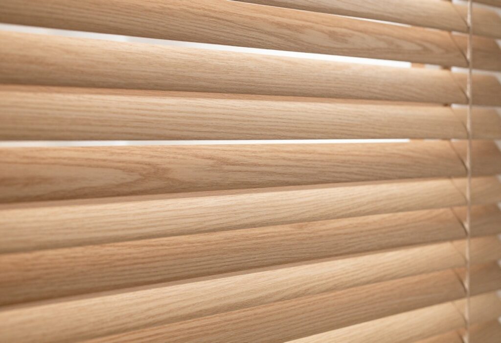 Clean faux wood blinds with sunlight shining through, no dust visible